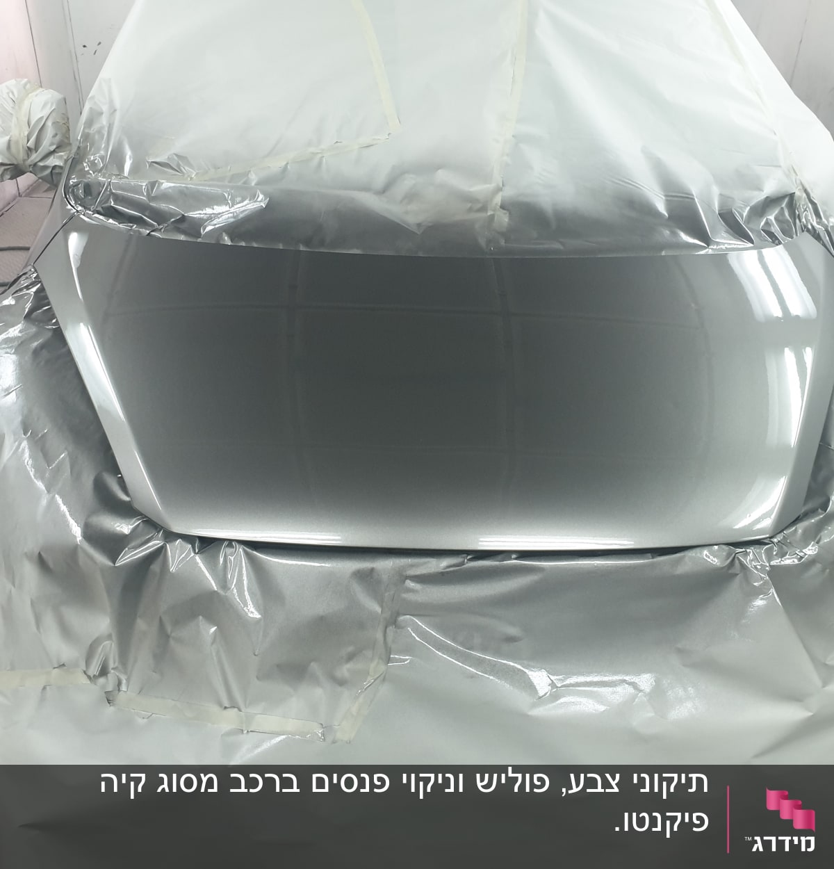 מכונית מכוסה בניילון בתהליך צביעה